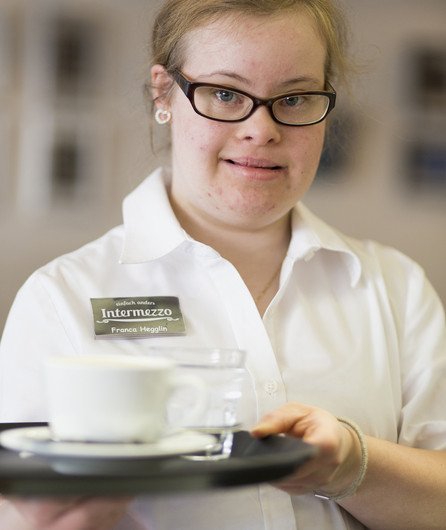 Junge Frau mit Beeinträchtigung am Arbeiten im Service