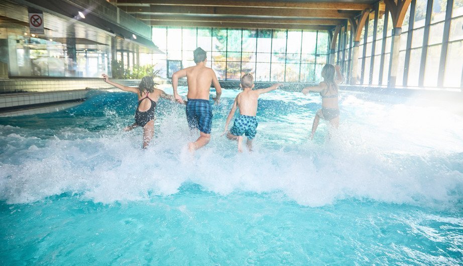 Vater mit zwei Kindern stürzen sich ins Wellenbad
